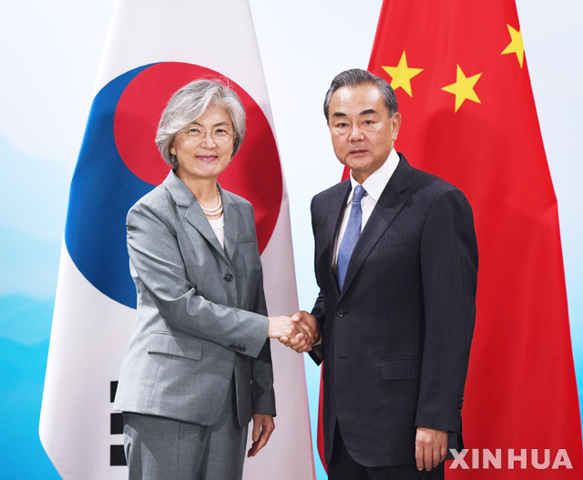 【베이징=신화/뉴시스】한중일 외교장관 회담 참석차 중국을 방문한 강경화 외교부 장관이 20일(현지시간) 중국 베이징 구베이수이전에서 왕이 중국 외교 담당 국무위원 겸 외교부장을 만나 악수하고 있다.강경화 장관은 왕이 국무위원과 1시간 정도 만나 양국 관계 강화와 한일 갈등, 한반도 문제 등을 논의했다. 2019.08.21.