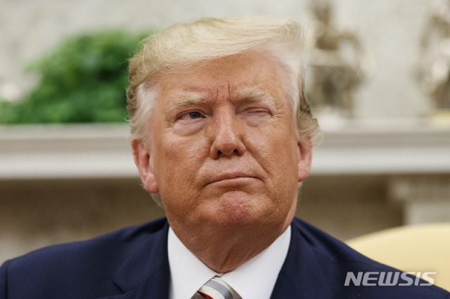 【워싱턴=AP/뉴시스】도널드 트럼프 미국 대통령이 20일(현지시간) 백악관 집무실에서 클라우스 요하니스 루마니아 대통령과 회담하며 기자들에게 윙크를 하고 있다. 2019.08.22.