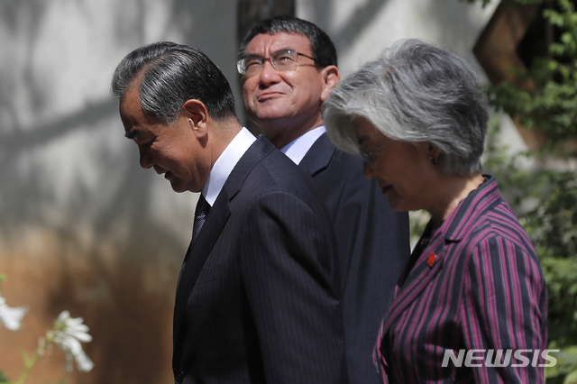  【베이징=AP/뉴시스】강경화(앞) 외교부 장관이 21일(현지시간) 중국 베이징 구베이 타운에서 열린 제9차 한중일 외교장관 회담을 마치고 왕이(가운데) 중국 외교 담당 국무위원 겸 외교부장, 고노 다로 일본 외무상과 공동기자회견장으로 향하고 있다. 2019.08.21. 