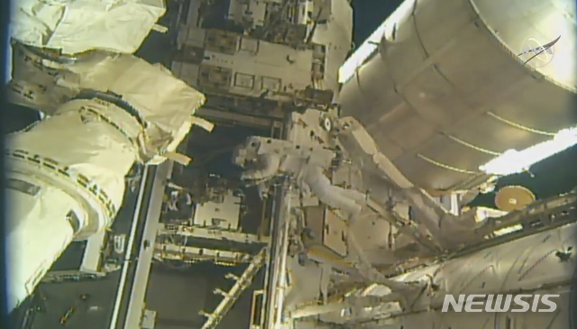 【워싱턴= AP/뉴시스】미 항공우주국 소속의 닉 헤이그와 앤드류 모건(가운데) 등 우주비행사 2명이 21일(미 현지시간) 국제우주정거장에서 민항 우주선 착륙장의 설치작업을 하고 있다. 이 재료와 장비는 지난 달 스페이스 엑스 화물선이 지상에서 우주정거장으로 운반해 온 것들이다.&nbsp;&nbsp;&nbsp; 
