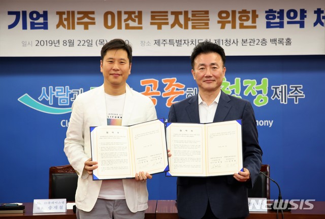 【제주=뉴시스】 전성태 제주도 행정부지사(오른쪽)와 송재철 (주)플레이스엠 총괄대표가 22일 오전 11시 제주도청 삼다홀에서 수도권 기업 제주 이전을 위한 투자 협약을 체결한 후 협약서를 들어보이고 있다. (제주도청 제공) 