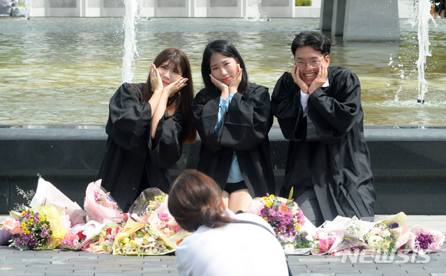 【전주=뉴시스】 김얼 기자= 전북대학교 2018학년도 후기 학위 수여식이 22일 전북 전주시 전북대학교 일원에서 실시된 가운데 졸업생이 기념촬영을 하며 환하게 웃고 있다. 2019.08.22.pmkeul@newsis.com