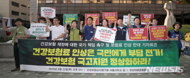 【서울=뉴시스】김선웅 기자 = 제17차 건강보험정책심의위원회에서 2020년 건강보험료율 결정을 앞두고 있는 22일 오후 서울 서초구 건강보험심사평가원 앞에서 무상의료운동본부가 기자회견을 열고 건강보험 재정에 대한 국가 책임 및 보험료 인상 반대를 촉구하고 있다. 2019.08.22.&nbsp; mangusta@newsis.com