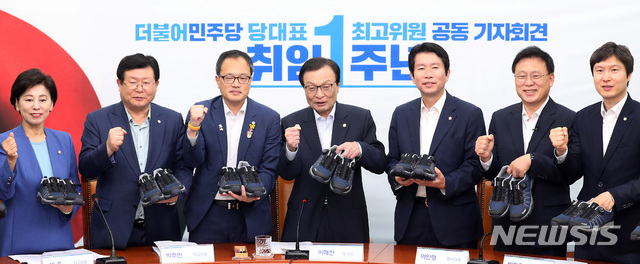 【서울=뉴시스】이종철 기자 = 23일 서울 여의도 국회에서 열린 더불어민주당 당대표-최고위원 취임1주년 공동 기자회견에서 이해찬 대표, 이인영 원내대표를 비롯한 최고위원들이 '열심히 뛰자'며 중소기업체 운동화를 들고 파이팅을 하고 있다. 2019.08.23. jc4321@newsis.com