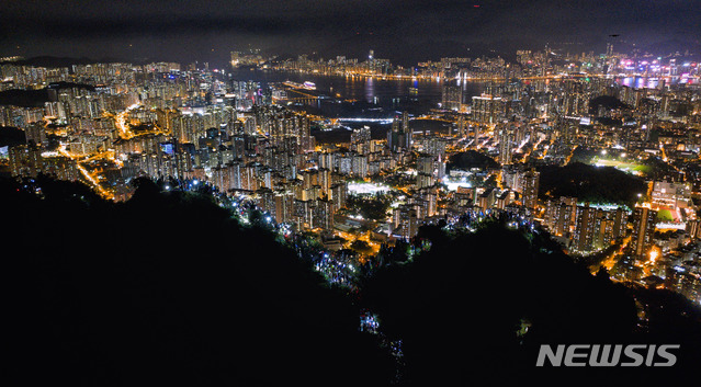 【홍콩=뉴시스】홍콩에서 16주 연속 범죄인 인도법(逃犯條例·송환법) 반대 시위가 지속되고 있는 가운데 23일 홍콩 시민들이 국제 사회에 송환법 반대 시위 지지를 호소하고자 60㎞에 달하는 거대한 인간 띠를 만드는 '홍콩의 길' 시위를 벌였다.사진은 인간 띠 시위 참가자들이 스마트폰 손전등 기능으로 만든 촛불이 반짝이고 있는 모습. 2019.08.24