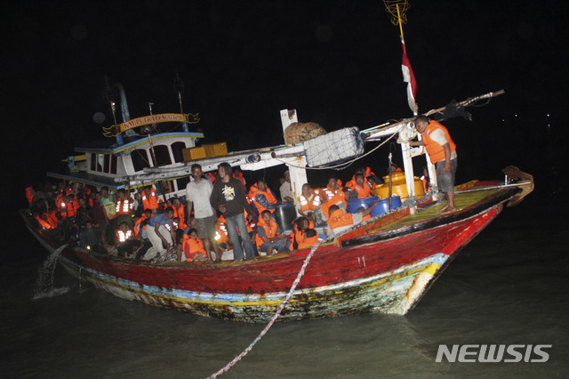 【수르네네프(인도네시아)=AP/뉴시스】한 어선이 23일 밤(현지시간) 인도네시아 자바섬 앞에서 화재 사고를 당한 유람선에서 탈출한 탑승객들을 구조해 해안가로 이동하고 있다. 2019.8.24