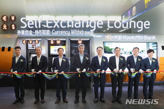 【서울=뉴시스】지난 23일 공항철도 공덕역 역사 내에서 열린 'KB무인환전센터 3호점' 개점 행사에서 김정국 공항철도 부사장(왼쪽 세 번째), 허인 KB국민은행장(왼쪽 네 번째), 김남일 KB국민은행 영업그룹 부행장(오른쪽 네 번째) 등 참석자들이 테이프 커팅식을 하고 있다.(사진=KB국민은행 제공)photo@newsis.com