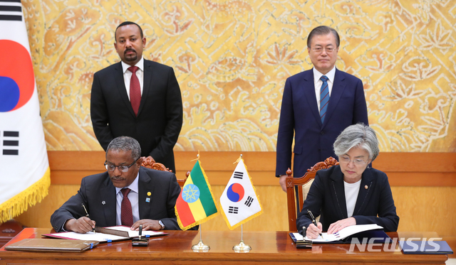【서울=뉴시스】전신 기자 = 강경화 외교부 장관과 게두 안다르가츄 외교부 장관이 26일 청와대 본관에서 문재인 대통령과 아비 아흐메드 알리 에티오피아 총리가 지켜보는 가운데 외교관 및 관용공무여권 사증면제 협정, 장관급 공동위 설립 양해각서를 체결하고 있다. 2019.08.26. photo1006@newsis.com