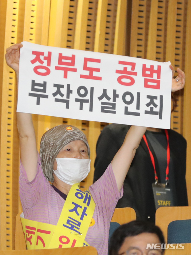 【서울=뉴시스】 전진환 기자 = 2019 가습기살균제참사 진상규명 청문회가 열린 27일 오전 서울시청 다목적홀에서 한 피해자가 피켓을 들고 있다. 청문회 첫날인 이날 주요 의제로는 가습기살균제 최초 개발 경위와 판매과정 및 가습기살균제 원료물질의 안전성 시험 관련 정부 책임 등의 문제가 채택됐다. 2019.08.27. amin2@newsis.com