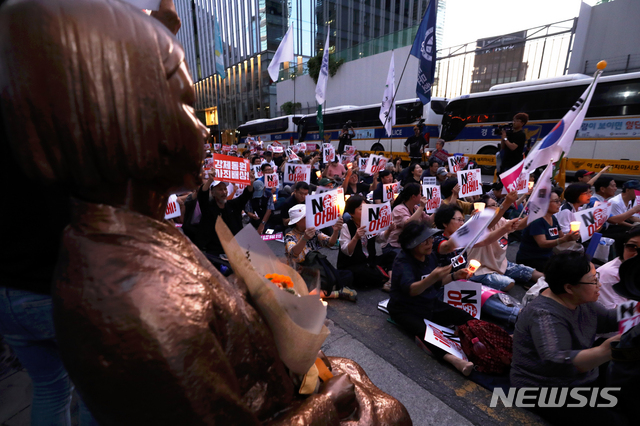 【서울=뉴시스】 이윤청 기자 = 31일 서울 종로구 구 일본대사관 앞에서 열린 '역사왜곡, 경제침략, 평화위협 아베규탄 7차 촛불문화제'에서 참가자들이 손팻말과 촛불을 들고 있다. 2019.08.31. radiohead@newsis.com