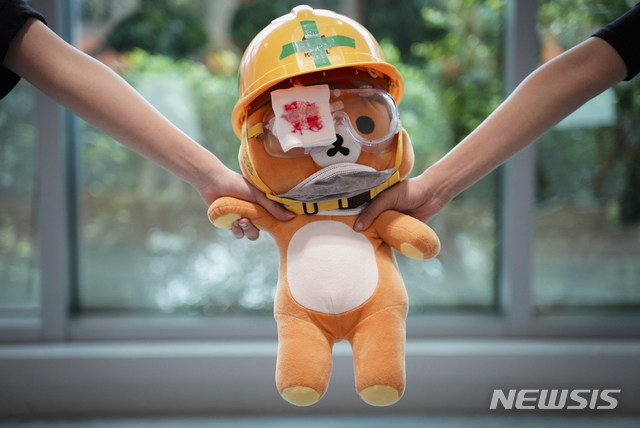 【홍콩=AP/뉴시스】5일 홍콩의 한 의과대학에서 학생들이 인간띠를 이뤄 시위를 벌이고 있는 두 학생이 리락쿠마 인형을 잡고 있다. 2019.09.06