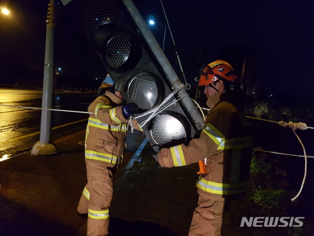 【서귀포=뉴시스】강경태 기자 = 7일 새벽 제주 서귀포시 대정읍 대정119센터 앞 도로에서 강풍에 신호등이 부러져 소방대원들이 안전조치에 나서고 있다. 2019.09.07. (사진=제주 서부소방서 제공) photo@newsis.com