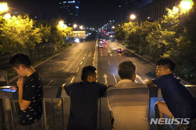 【베이징=AP/뉴시스】2019년 9월 7일 밤 베이징의 한 육교 위에 건국 70년 기념 군사 퍼레이드 예행연습을 지켜보려는 시민들이 모여 군의 예행연습 대열을 기다리고 있다.