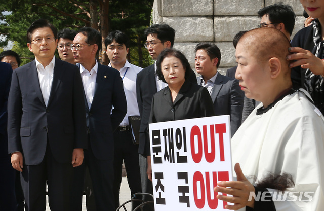 【서울=뉴시스】이종철 기자  = 11일 서울 여의도 국회 본관 앞 계단 밑에서 자유한국당 황교안 대표가 조국 법무부장관 임명 철회를 요구하며 삭발을 하는 박인숙 의원을 착잡한 표정으로 바라보고 있다. 2019.09.11. jc4321@newsis.com