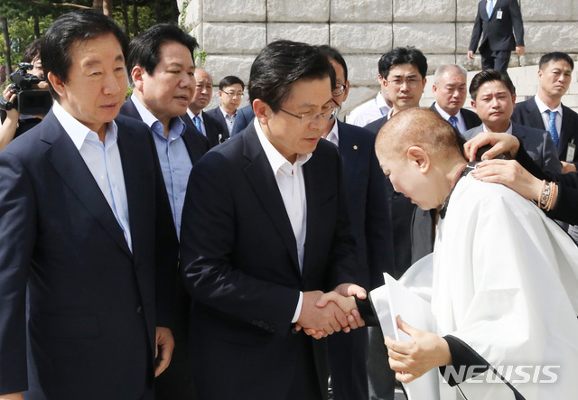 【서울=뉴시스】이종철 기자  = 11일 서울 여의도 국회 본관 앞 계단 밑에서 자유한국당 황교안 대표가 조국 법무부장관 임명 철회를 요구하며 삭발을 한 박인숙 의원을 격려하고 있다. 2019.09.11. jc4321@newsis.com