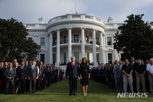【워싱턴= AP/뉴시스】 24일 미국 하원이 도널드 트럼프 미국 대통령에 대한 탄핵 조사 개시를 공식 발표한 가운데 백악관은 이에 대해 "당파적 정치공세"라고 비난했다. 사진은 지난 11일 백악관 남쪽 정원에서 직원들과 함께 9.11 묵념을 올리는 트럼프 대통령과 멜라니아. 2019.09.25.