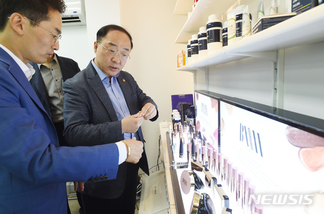 【서울=뉴시스】 김진아 기자 = 홍남기 부총리 겸 기획재정부 장관이 12일 추석연휴를 맞아 인천 남동공단 소재 수출중소기업 아주화장품를 방문, 관계자로부터 제품설명을 듣고 있다. 2019.09.12. (사진=기획재정부 제공) photo@newsis.com