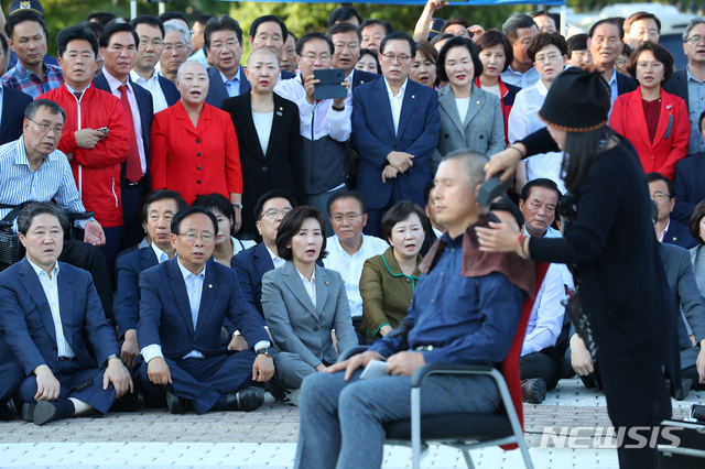 【서울=뉴시스】전신 기자 = 황교안 자유한국당 대표가 16일 서울 종로구 청와대 앞 분수대 광장에서 조국 법무부 장관의 사퇴를 촉구하며 삭발을 하는 가운데 한국당 의원 등 관계자들이 지켜보고 있다. 2019.09.16. photo1006@newsis.com