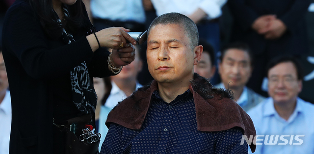 【서울=뉴시스】전신 기자 = 자유한국당 황교안 대표가 16일 서울 종로구 청와대 앞 분수대 광장에서 조국 법무부 장관의 사퇴를 촉구하며 삭발을 하고 있다. 2019.09.16. photo1006@newsis.com
