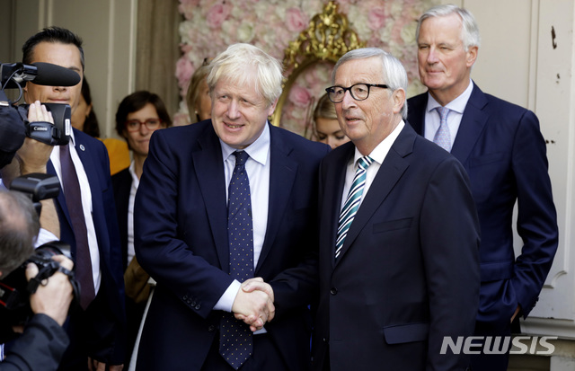 존슨 영국 총리와 융커 유럽연합 집행위원장이 16일 룩셈부르크에서 만나 오찬 협상 전 악수 포즈를 취하고 있다. 오른쪽 미셸 바르니에 EU 협상대표가 서 서 있다&nbsp; AP