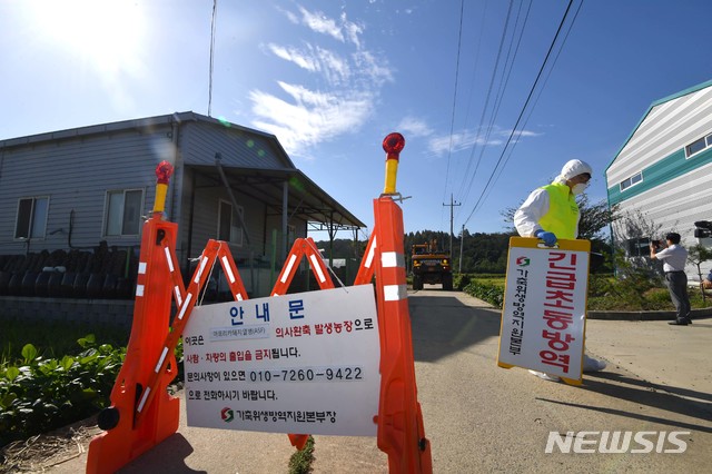 【파주=뉴시스】김선웅 기자 = 국내에서 처음으로 가축전염병인 아프리카돼지열병(ASF)이 발생한 17일 오전 경기 파주시 연다산동의 한 돼지농장에서 방역 관계자들이 농장으로 향하는 길목을 차단, 통제하고 있다.농림축산식품부는 17일 오전 6시30분께 경기도 파주시 연다산동의 한 돼지농장을 ASF 발생 농가로 확진했다고 밝혔다. 2019.09.17. mangusta@newsis.com