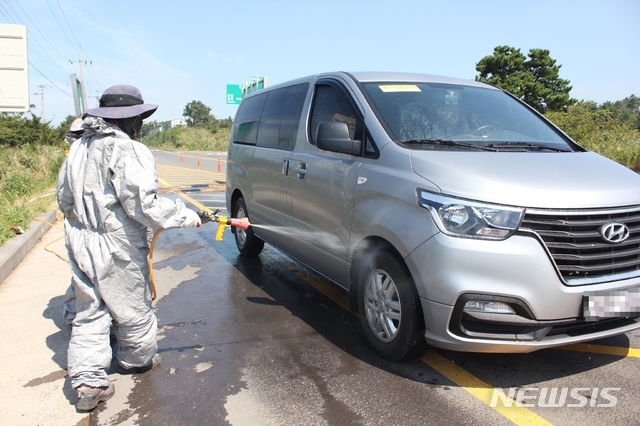 【제주=뉴시스】강경태 기자 = 18일 오후 제주시 한립읍 금악리 금악2교차로에 설치된 거점 소독시설에서 초소 근무자들이 축산시설 출입차량에 대한 소독 작업을 벌이고 있다. 2019.09.18. ktk2807@newsis.com
