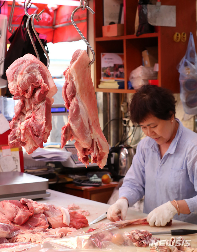 【서울=뉴시스】박주성 기자 = 국내에서 처음으로 아프리카돼지열병(ASF)이 17일 발병하면서 돼지고기 가격이 급등했다. 농림축산식품부는 18일 "현재 돼지고기 수급은 사육마릿수가 평년 대비 13% 많고 육가공업체 등이 충분한 재고물량을 확보하고 있어 가격은 낮은 수준으로 유지되어 왔다"고 밝혔다. 그러나 전날 돼지고기 도매가격이 32.4% 상승한 것은 이동중지명령에 따른 단기간 물량 부족을 우려한 중도매인이 선제적으로 물량을 확보하면서 나타난 일시적 가격 상승으로 보여진다고 설명했다. 사진은 18일 오후 서울 성동구 마장동 축산시장에서 한 상인이 돼지고기를 손질하고 있는 모습. 2019.09.18. park7691@newsis.com