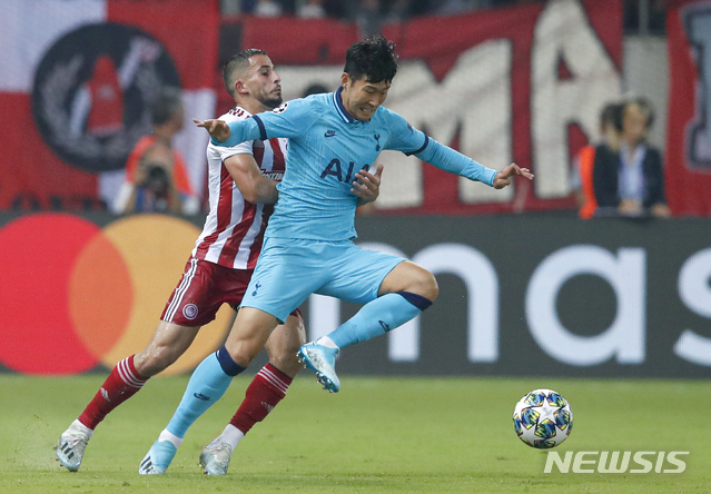 Tottenham's Son Heung-min, right, challenges for the ball with Olympiakos' Omar Elabdellaoui during the Champions League group B soccer match between Olympiakos and Tottenham, at the Georgios Karaiskakis stadium, in Piraeus port, near Athens, Wednesday, Sept. 18, 2019. (AP Photo/Thanassis Stavrakis)
