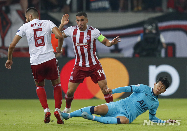Tottenham's Son Heung-min falls after a tackle by Olympiakos' Omar Elabdellaoui, center, during the Champions League group B soccer match between Olympiakos and Tottenham, at the Georgios Karaiskakis stadium, in Piraeus port, near Athens, Wednesday, Sept. 18, 2019. (AP Photo/Thanassis Stavrakis)