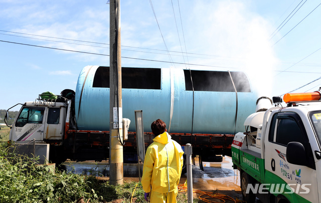 【연천=뉴시스】 전진환 기자 = 19일 오전 아프리카돼지열병(ASF)이 발생한 경기도 연천군의 한 돼지 농장에서 방역 관계자들이 농장으로 반입하는 돼지 매몰용 탱크에 방역작업을 하고 있다 2019.09.19. amin2@newsis.com