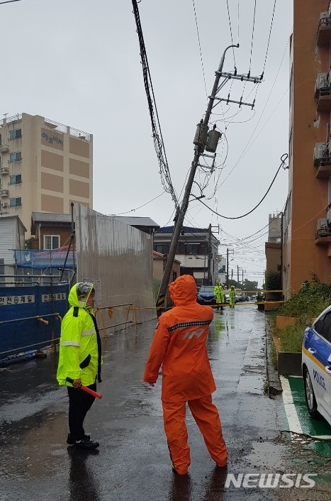 【제주=뉴시스】22일 오전 제주시 건입동에 있는 전신주가 강풍의 영향으로 기울어져 경찰과 한전, 소방당국이 안전조치에 나서고 있다. 2019.09.22. (사진=제주소방서 제공) photo@newsis.com