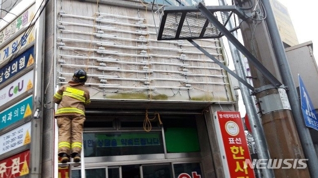 【서귀포=뉴시스】22일 오전 제주 서귀포시 표선면 소재 한 상가에서 제17호 태풍 ‘타파’ 강풍의 영향으로 간판이 파손돼 소방대원이 안전조치에 나서고 있다. 2019.09.22. (사진=제주 동부소방서 제공) photo@newsis.com
