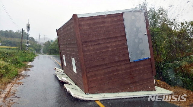 【함평=뉴시스】변재훈 기자 = 태풍 '타파'가 접근하고 있는 22일 오전10시2분께 전남 함평군 함평읍 장년리에서 조립식 창고 건물이 강풍에 도로로 쓰러져 소방당국이 안전조치에 나섰다. 2019.09.22. (사진=함평소방 제공) photo@newsis.com