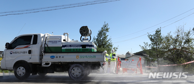 【김포=뉴시스】 전진환 기자 = 23일 오전 아프리카 돼지열병(ASF) 의심 신고가 접수된 경기도 김포시의 한 돼지농장 입구 도로에서 방역관계자들이 방역을 하고 있다. 2019.09.23.&nbsp; amin2@newsis.com 