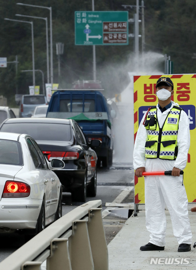 【인천=뉴시스】최동준 기자 = 강화군에 아프리카돼지열병(ASF) 의심 사례가 총 2건이 접수된 25일 인천 강화대교에서 방역당국이 강화도로 진입하는 차량에 방역 작업을 하고 있다. 2019.09.25.&nbsp; photocdj@newsis.com