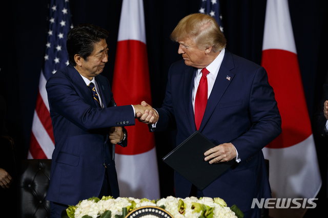 【뉴욕=AP/뉴시스】도널드 트럼프(오른쪽) 미국 대통령과 아베 신조 일본 총리가 25일(현지시간) 유엔총회가 열리고 있는 뉴욕의 인터콘티넨탈 호텔에서 미·일 무역협정서 서명 후 악수하고 있다. 2019.09.26.