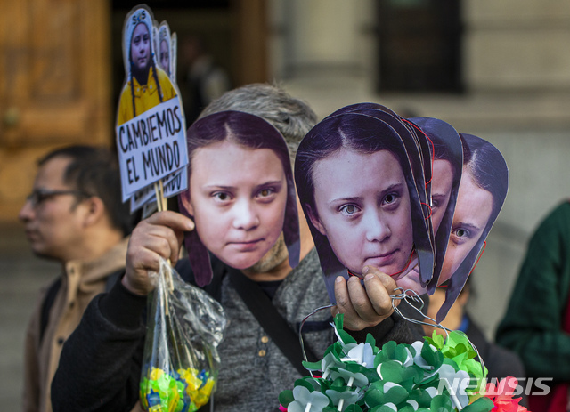 【산티아고=AP/뉴시스】27일(현지시간) 칠레 산티아고 기후집회에서 한 남성이 '환경투사' 그레타 툰베리의 얼굴이 그려진 가면을 판매하고 있다. 2019.09.28.