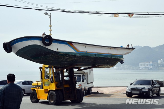 【부산=뉴시스】 하경민 기자 = 제18호 태풍 '미탁'(MITAG)이 북상 중인 30일 부산 해운대구 송정해수욕장 인근 송정어촌계 소속 어민들이 중장비를 동원해 소형 어선을 도로변으로 옮기고 있다. 2019.09.30. yulnetphoto@newsis.com