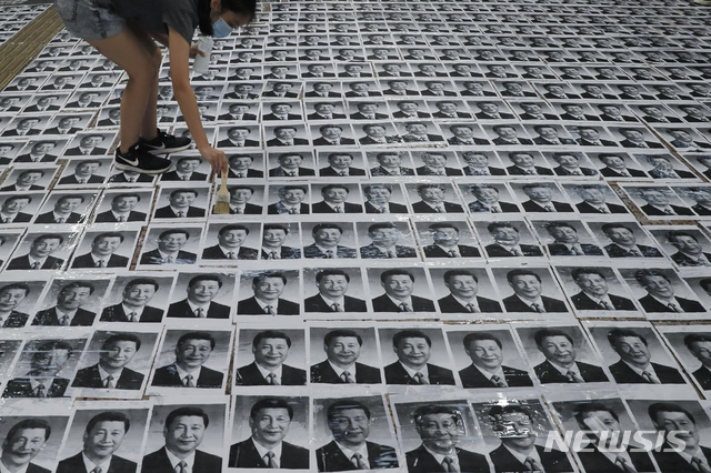 【홍콩=AP/뉴시스】1일(현지시간) 홍콩의 '레넌의 벽'(Lennon Wall)에 한 시위대원이 시진핑 중국 국가주석의 사진을 사람들이 밟고 지나가도록 바닥에 붙이고 있다.  홍콩 시위대는 중국의 70주년 국경절인 1일 경찰의 불허 방침에도 대규모 시위를 벌일 것을 예고한 바 있다.시위대는 중국은 국경절을 축하하지만 홍콩은 톈안먼 사건 등으로 수많은 사람이 목숨을 잃었다면서 이를 ‘추모’할 것이라고 밝혔다. 2019.10.01.