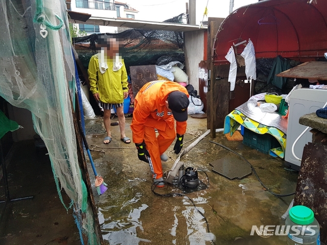 【제주=뉴시스】제18호 태풍 ‘미탁’이 북상하면서 내린 빗줄기에 2일 오전 제주시 노형동에 있는 주택이 침수돼 소방대원이 배수지원에 나서고 있다. 2019.10.02. (사진=제주소방서 제공) photo@newsis.com