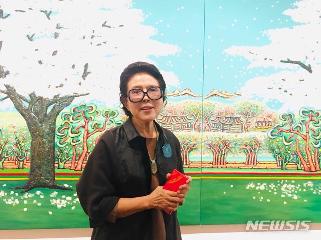 【서울=뉴시스】박현주 미술전문기자= 2일 오전 서울 평창동 가나아트센터에서 '하인두 작고 30주기 기념:류민자' 개인전을 연 류민자 화백이 작품앞에서 포즈를 취했다. 故 하인두 화백의 산소가 있는 곳에 벗꽃이 활짝 핀 풍경을 담았다는 신작이다.