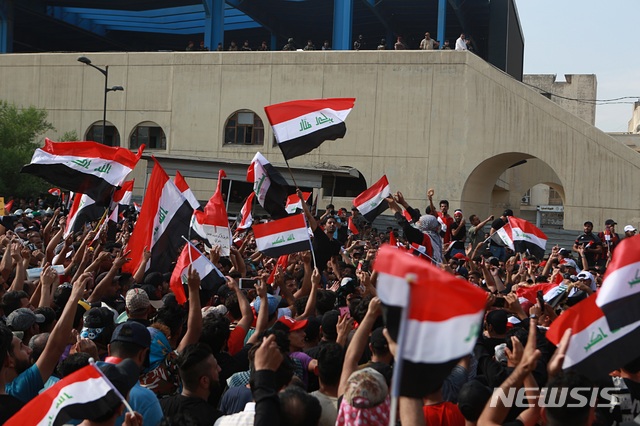 【바그다드=AP/뉴시스】1일(현지시간) 이라크 수도 바그다드의 타흐리르 광장에서 이라크 국기를 든 시위대가 구호를 외치며 반정부 시위를 벌이고 있다. 최근 수도와 전기 부족, 청년실업 등에 항의하는 시위가 전국 주요 도시에서 이어지는 가운데 1명이 숨지고 200여 명이 다쳤다고 현지 관계자가 밝혔다. 시위대는 IS와의 전쟁도 끝났지만 부패한 지도자 때문에 달라진 게 없다며 시위를 이어가고 있다. 2019.10.02.
