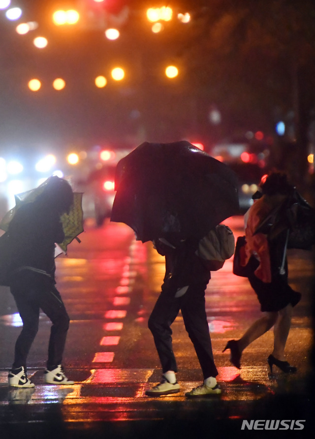 【부산=뉴시스】 하경민 기자 = 제18호 태풍 '미탁'(MITAG)이 북상하면서 부산지역에 '태풍경보'가 발효된 2일 오후 부산 해운대구의 한 횡단보도에서 시민들이 비바람에 맞서 힘겹게 걸어가고 있다. 2019.10.02. yulnetphoto@newsis.com