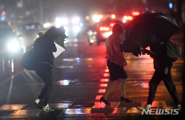 【부산=뉴시스】 하경민 기자 = 제18호 태풍 '미탁'(MITAG)이 북상하면서 부산지역에 '태풍경보'가 발효된 2일 오후 부산 해운대구의 한 횡단보도에서 시민들이 비바람에 맞서 힘겹게 걸어가고 있다. 2019.10.02. yulnetphoto@newsis.com