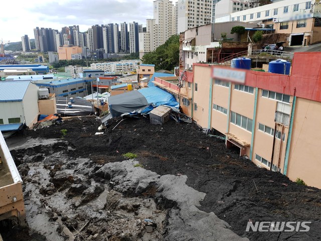 【부산=뉴시스】 3일 오전 9시 5분께 부산 사하구 구평동의 한 야산에서 산사태가 발생, 토사가 쏟아지면서 인근 샌드위치패널 구조의 공장과 주택 1채, 천막으로 된 식당 가건물 1개동 등을 덮쳤다. 이로 인해 주택에 3명, 식당에 1명 등 총 4명이 매몰된 것으로 추정되고 있다. 2019.10.03. (사진=부산소방재난본부 제공) photo@newsis.com 