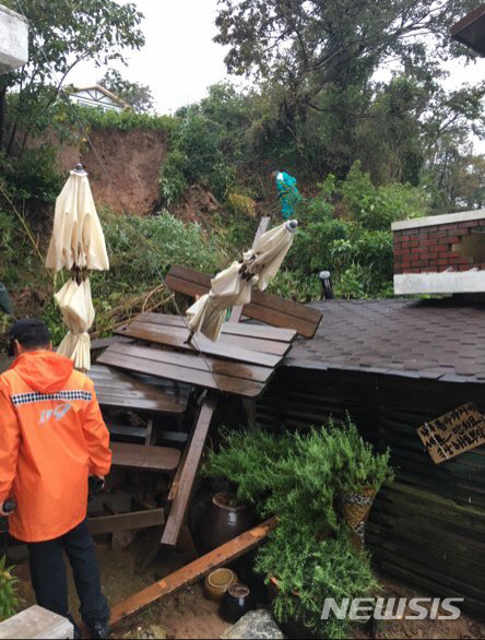 【장흥=뉴시스】변재훈 기자 = 태풍 '미탁'이 위력을 떨친 지난 2일 낮 전남 장흥군 회진면 노력도 한 주택에 토사가 유입돼 소방당국이 안전조치에 나섰다. 2019.10.03. (사진=강진소방 제공) photo@newsis.com 