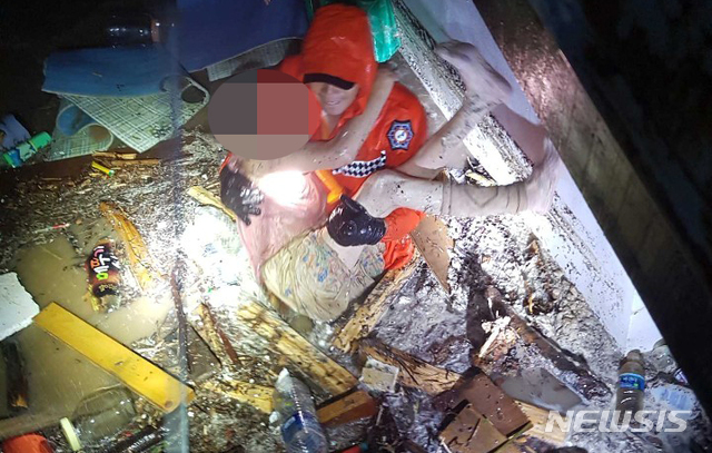 【삼척=뉴시스】 김경목 기자 = 강원 삼척소방서 소방관이 3일 오전 북상 중인 제18호 태풍 '미탁(MITAG)'이 몰고 온 폭우로 침수 피해를 입은 삼척시 원덕읍 갈남리에서 할머니를 구조하고 있다. 2019.10.03. (사진=삼척소방서 제공) photo＠newsis.com 