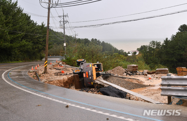 【삼척=뉴시스】김경목 기자 = 3일 오전 제18 태풍 '미탁(MITAG)'이 몰고 온 폭우로 강원도 삼척시 7번 국도에서 도로가 붕괴돼 중장비가 넘어져 있다. 2019.10.03. (사진=삼척시청 제공)photo＠newsis.com