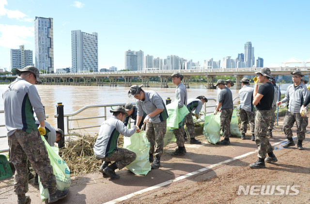 3일 오전 울산시 중구 태화강둔치에서 53사단 127연대 장병들이 폭우에 떠밀려온 쓰레기를 치우고 있다.