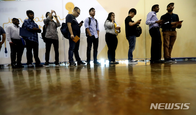 In this Sept. 17, 2019, photo job seekers line up to speak to recruiters during an Amazon job fair in Dallas. On Friday, Oct. 4, the U.S. government issues the September jobs report. (AP Photo/LM Otero)